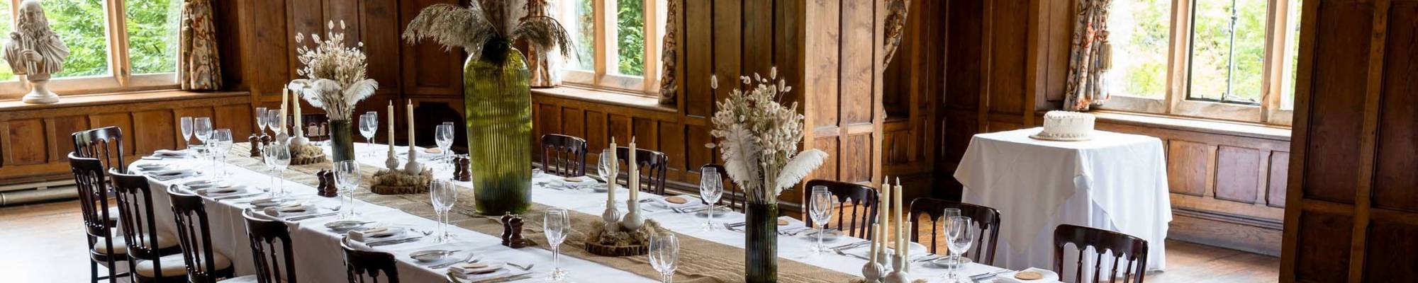 Château Rhianfa Banquet Hall beautifully set for a wedding, with elegant table settings, floral centrepieces, and soft ambient lighting ready for the couple’s arrival.