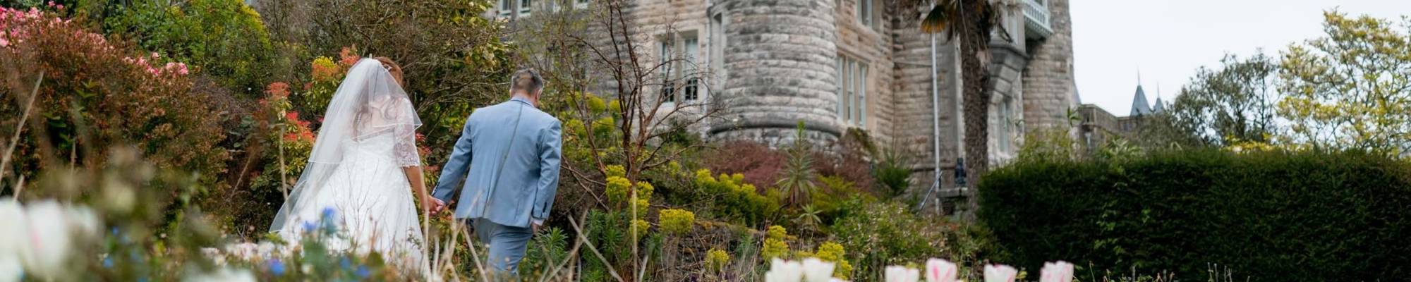 Bride and groom sharing a quiet moment in the gardens of Château Rhianfa overlooking the Menai Strait.